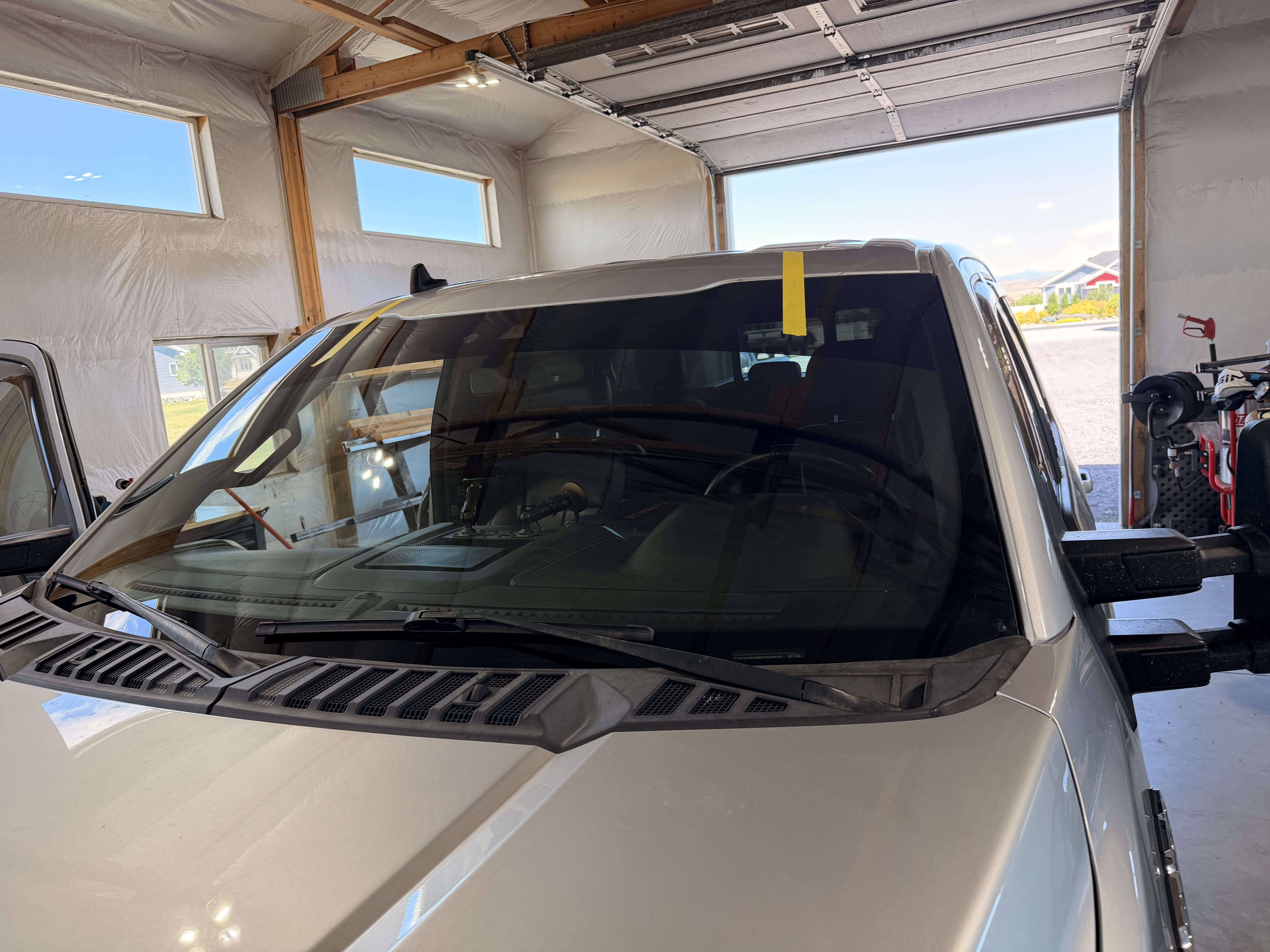 Newly installed windshield on a truck inside the shop garage
